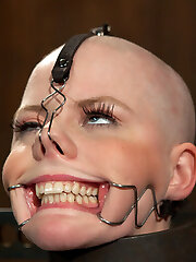 Alani Pi is no plain model. Her uber-cute behavior is disarming compared to the deep and perverted lady on the interior. For her live showcase, she consented and even requested a head shaving. Its very unusual to get such a request. A model makes a lot of money based off of appearance, and no hair is a very extreme thing for a super-steamy cunt like Alani to take on.Wasting no time, Alani is installed in metal stocks with her wrists trapped in leather cuffs and metal and her neck packaged in metal. The stocks are deliberately a little high, making her chin pitch slightly upward and her legs splayed open by cuffs and ropes. The idea is to make the process clumsy and already she is fidgeting nervously in her restraints.The electric monster clippers click on in an excited humming frenzy. She looks calm but if you study her closely, she is quaking. Slightly able to make eye contact and furtive sideways sights through her long crops, she might be reconsidering... Claire tho is very committed and begins shaving only half her head so we can watch the stark comparison of clean-shaved and not from our soon to be smooth-shaven Alani. Patiently and leisurely, her hair disappears and with it all capability to identify with who she previously was. Now she is just a shell... a vessel... one that we intend to fill to the edge with agony and pleasure; shaping, forming, and manipulating.