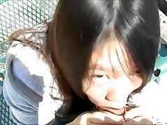 Japanese woman blowing guys in the park in broad day light