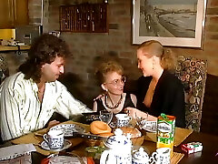 dos impresionantes chicas alemanas compartiendo una polla cargada en la mesa de la cocina