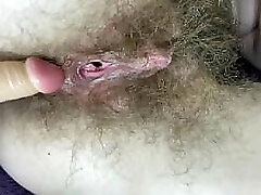 Hairy girl humps her wet big clit gash with dildo in close up