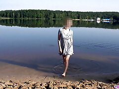 une fille nudiste fait trempette maigre sur une plage