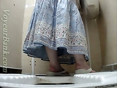 सफेद परिपक्व महिला पोशाक में पेशाब शौचालय कमरे में