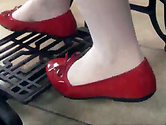Pretty dark haired damsel Petra wears red flats while working with sewing machine