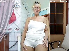 Lukerya in the kitchen in wet white underpants, bottom view