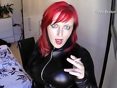 ginger-haired smoking in leather catsuit