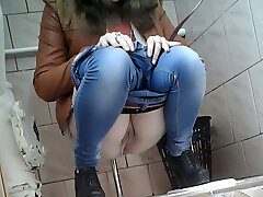 Slender girl in very tight blue jeans filmed in the rest room bedroom