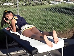 Cheerleader sans panties sunbathing on the massage table