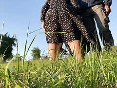 Mother-in-law in a dress bent over deeply to show you how she pees in nature
