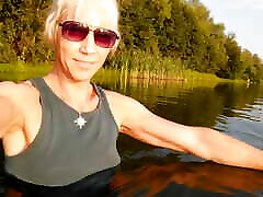 सूर्यास्त के समय खेल में झील में तैरना । . गीले लेगिंग और टी-शर्ट ।