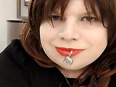 Sissy Kelli walks a hotel corridor wearing a penis gag