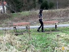 Raven haired petite babe sits on bench and pisses