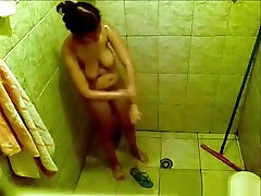Voyeur tapes a big boobed brunette girl showering