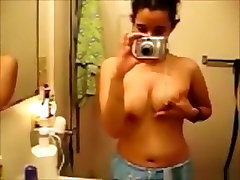 girl strips in front of the bathroom mirror and rubs her hairy pussy on the toilet