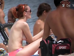Cute blonde, redhead and brunette are lying naked on the beach