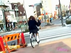 亚洲女孩得到裙子sharked在她的自行车的人附近