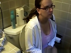 Busty woman in bathroom toilet peeing