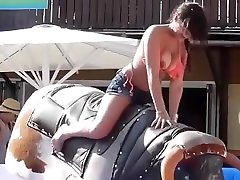 Bikini long cloth rides mechanical bull outdoors