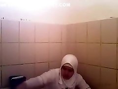 mujer árabe va a orinar en un baño público