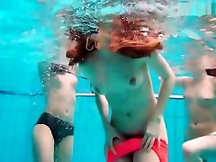 Three nude girls have redhead playboy bunny costume underwater