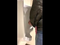 guy stroking his cock in the urinals