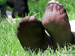 pies en medias de red calcetines en la hierba