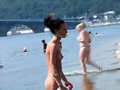 夸夸其谈的年轻裸体主义者辣妹日光浴裸体在海滩