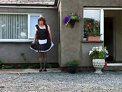 sissy maid neil en su uniforme de sirvienta fuera de su casa