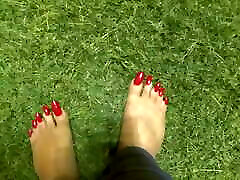 długie czerwone palce na trawie