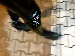 a crossdresser in high wedge platform shoes and pasien wit doctor leggings is walking the streets at night