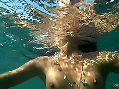 Nude model swims on a public beach in Russia.