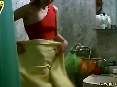 Ugly blonde in red top spreads her slim legs a bit to pee in bath tub