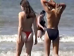 Two young blonde chicks walking on the sandy frst ass scene topless