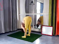雷吉娜诺尔。 瑜伽在黄色紧身衣做瑜伽在健身房。 一个没有内裤的女孩正在做瑜伽。 运动员在p训练