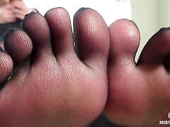 स्वादिष्ट अलग पैर की उंगलियों के साथ काले मोज़ा में देवी पैर छेड़ो