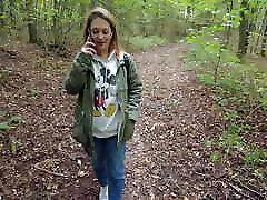 Kinky brunette strolls through woods talking on a phone and gets horny