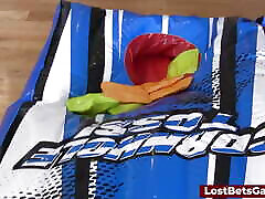 zwei schöne mädchen spielen ein stripspiel namens cornhole toss