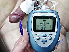 cbt, spiele mit strom. domina nika hat einen elektrostimulator an den schwanz und die eier ihres bdsm-sklaven angeschlossen