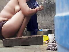 In the bath house in the courtyard outside the open house, the stepsister is bathing wearing red tights, all the clothes are ope