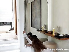 une femme de chambre sexy en robe transparente sans soutien-gorge ni culotte nettoie le miroir pour son patron. amy haze