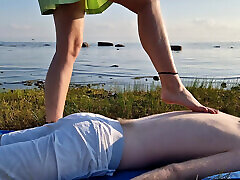 massaggio ai piedi da ragazza con le dita lunghe, lunghe gambe sottili in gonna