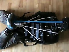 muzzled slave is hogtied in the straitjacket
