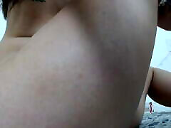 Beautiful Latina with a cute face lies on her side on the bed