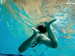 Lovely natural chick exposes her sexy rounded ass and natural tits underwater