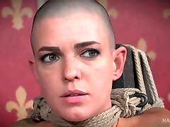Slender white young chick with shaved head bound to the post